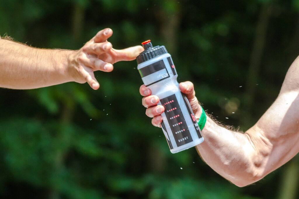 Eine Trinkflasche wird während dem Sport übergeben
